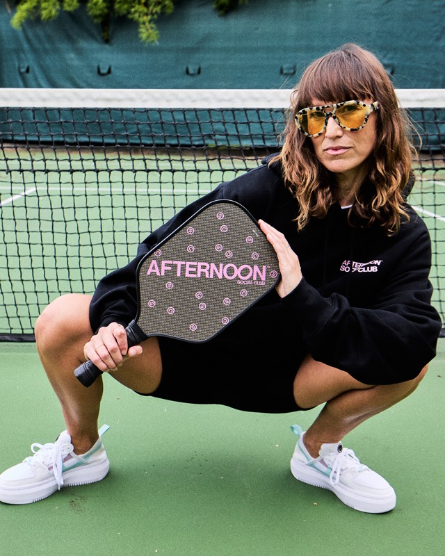A player in an Afternoon Social Club hoodie holding a paddle